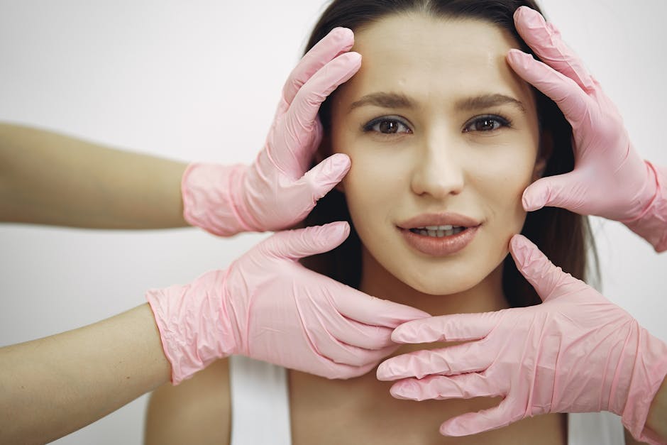 Gloved hands framing a client's face before a cosmetic treatment